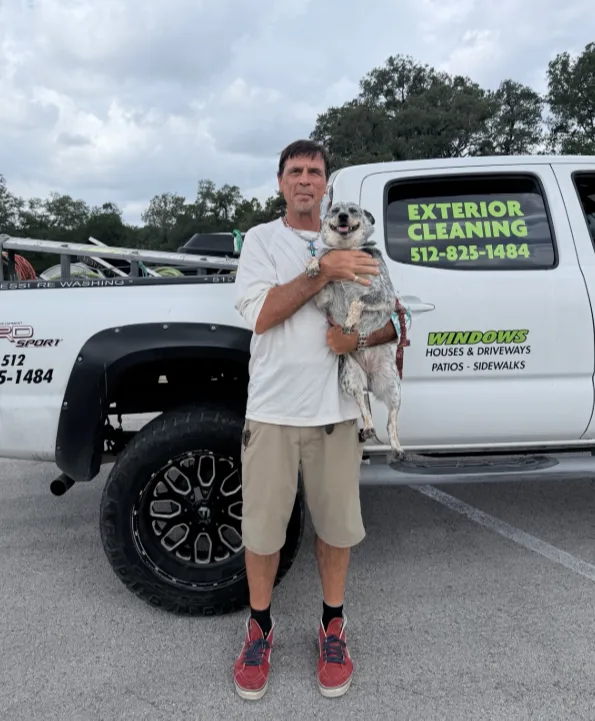 Brett standing with a dog beside a work truck