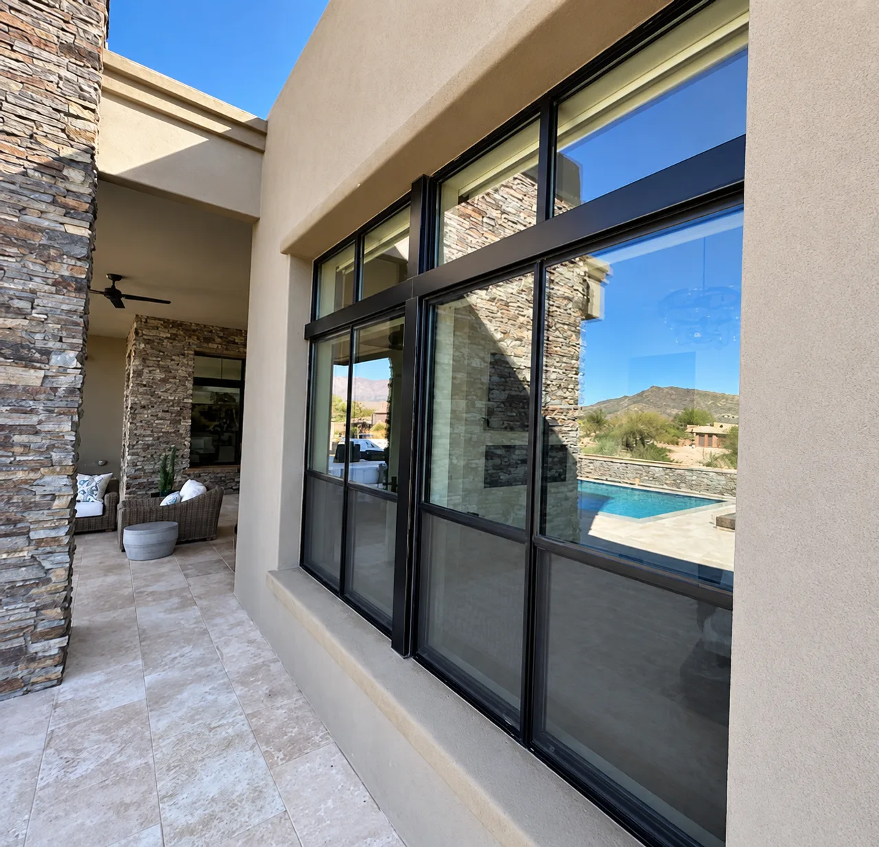 Tall architectural windows reflecting a patio